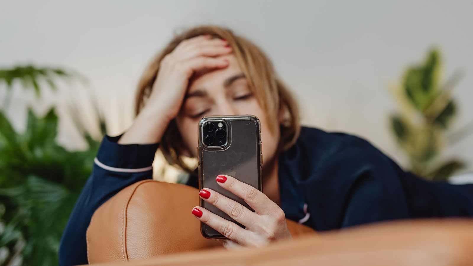 Junge Frau schaut besorgt auf ihr Smartphone &ndash; Verlustangst im Alltag